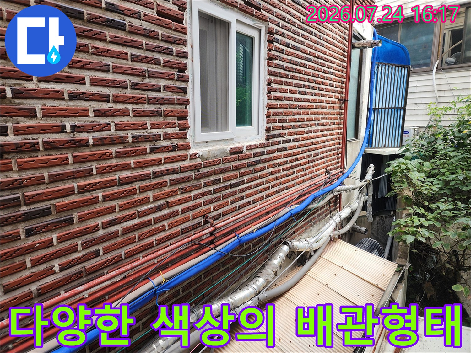 파란색과 은색 단열재로 마감된 복합적인 형태의 외부 수도 배관 시설.