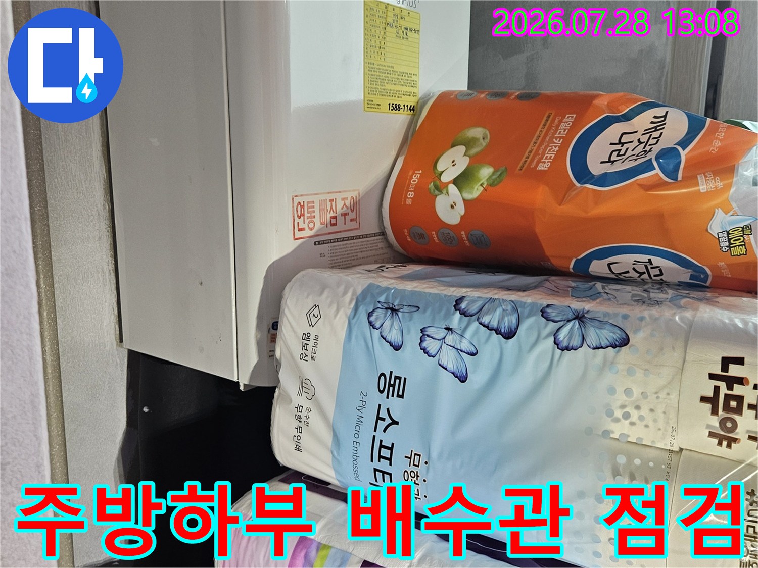 싱크대 아래쪽 세제와 세제통이 놓인 공간의 배수 트렌치 및 연결 부위 상태를 확인하는 모습