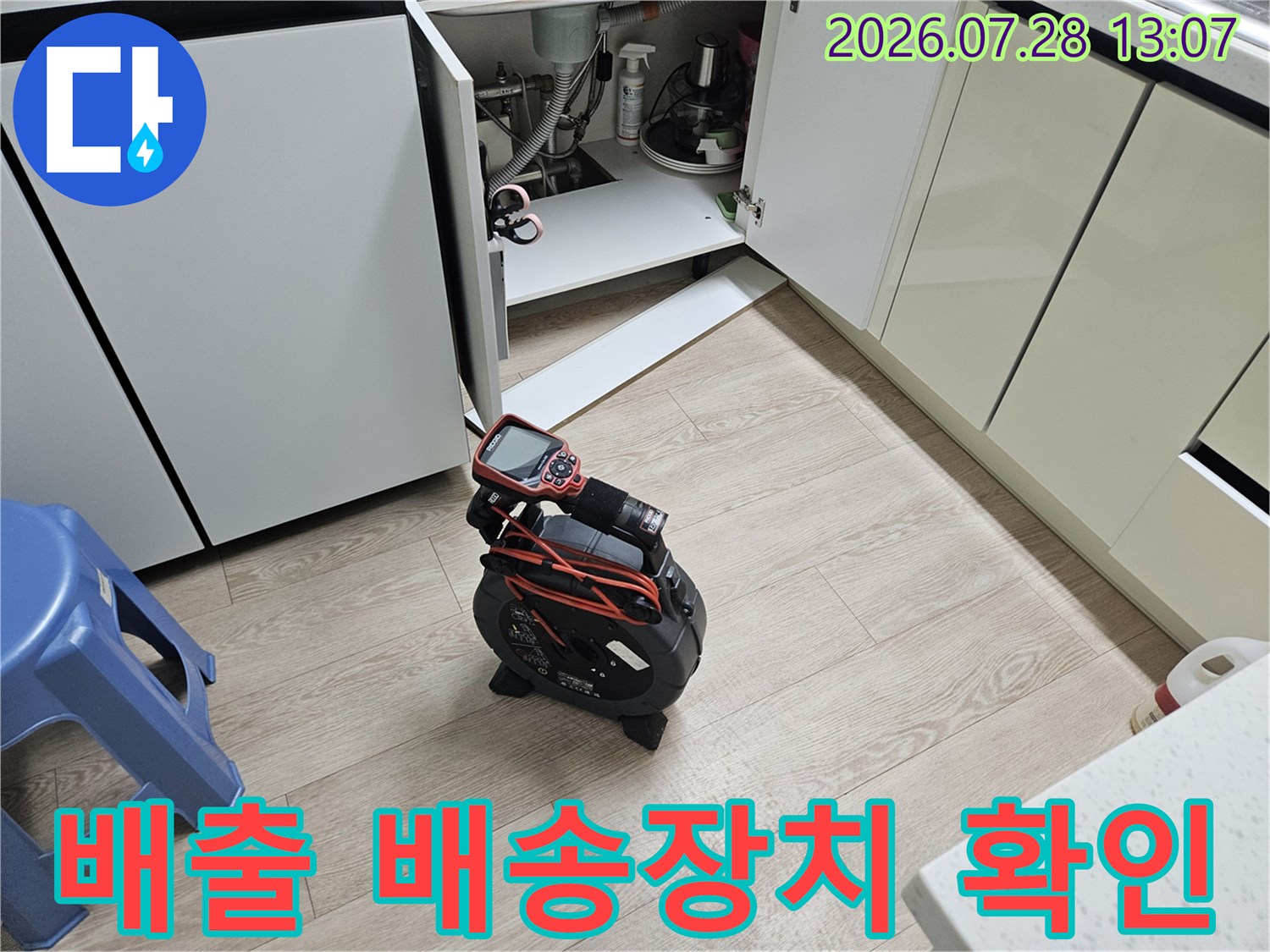 싱크대 하단 공간에서 배수 시스템의 연결 부위 상태를 점검하는 모습