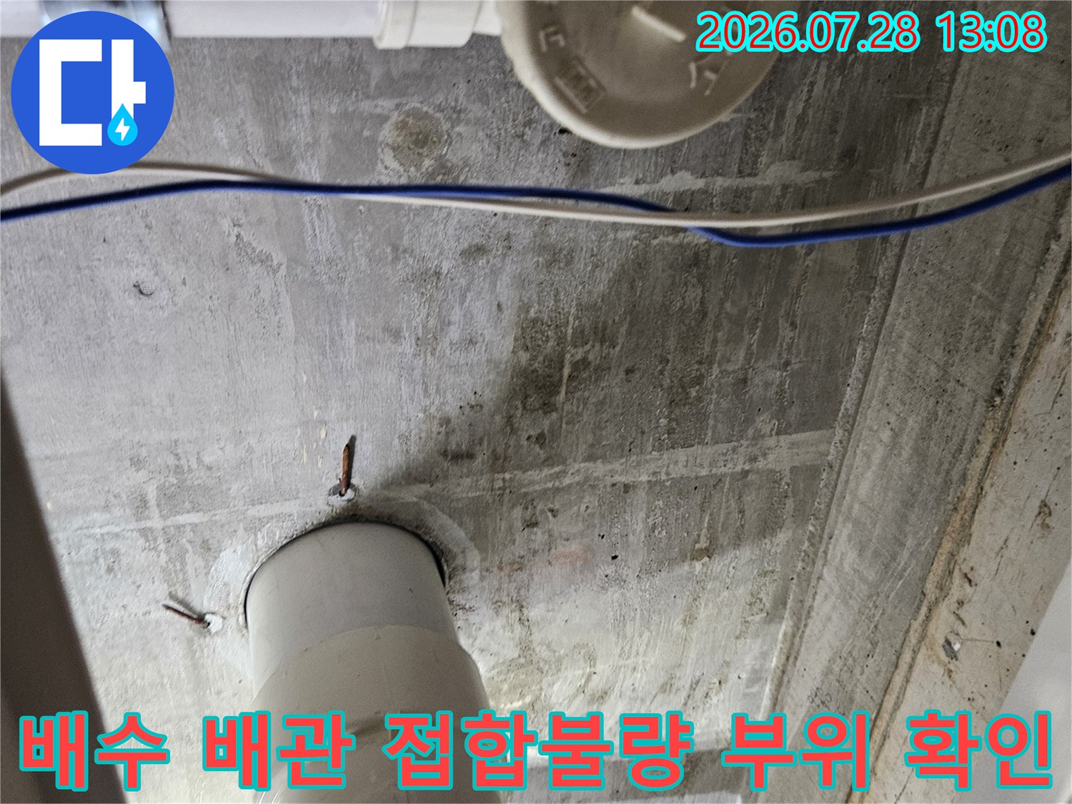 싱크대 하부 공간의 굴곡진 배수 배관 연결부를 집중 점검하는 현장 사진