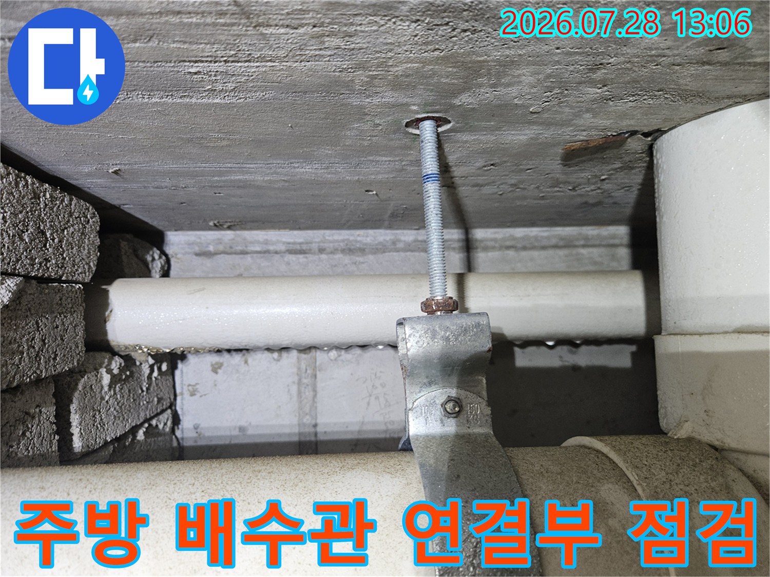 하얀색 배수관의 연결 부위와 고정용 볼트를 점검하는 모습