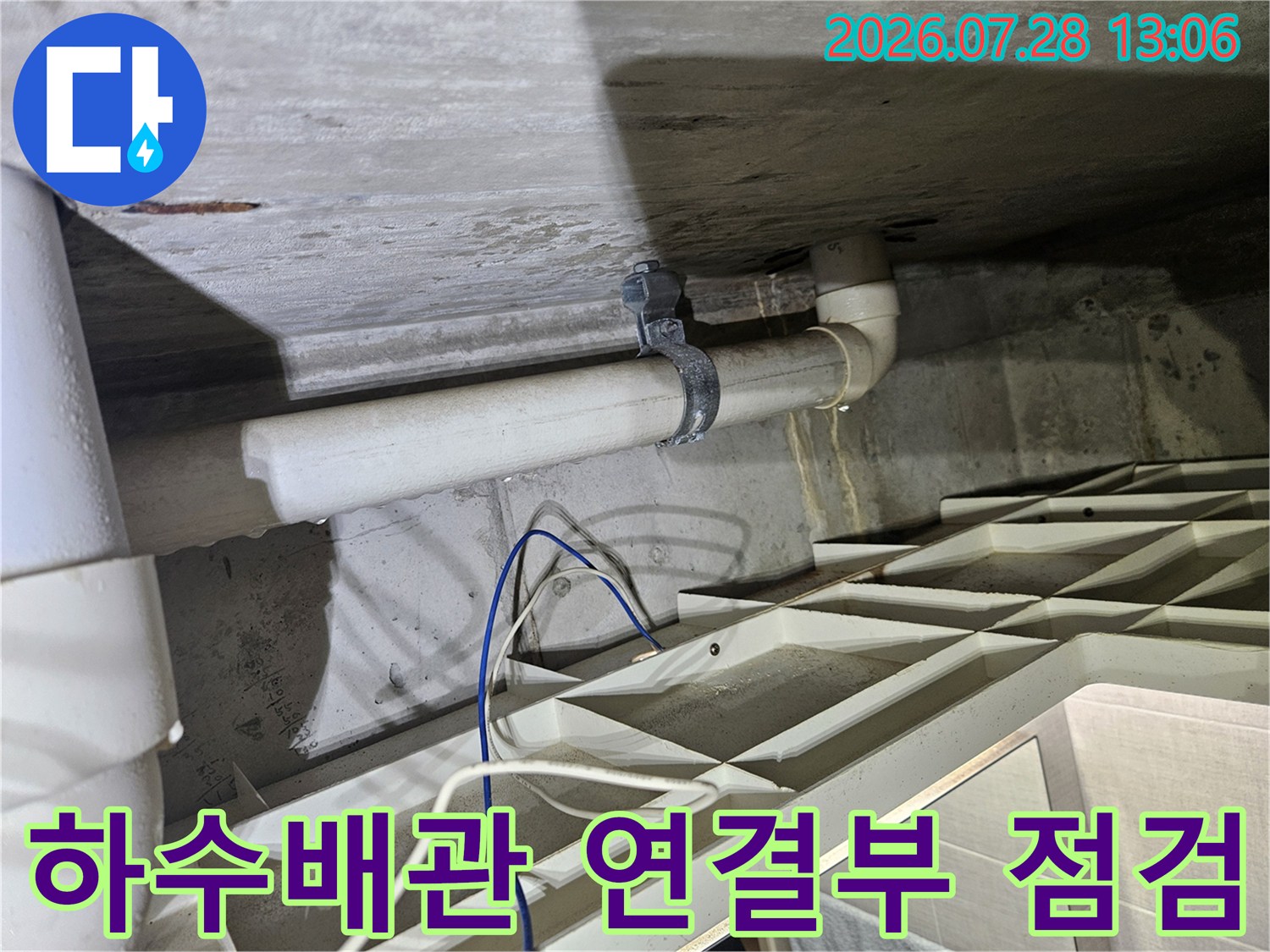 흰색으로 마감된 배수 배관의 연결 부위 점검 모습