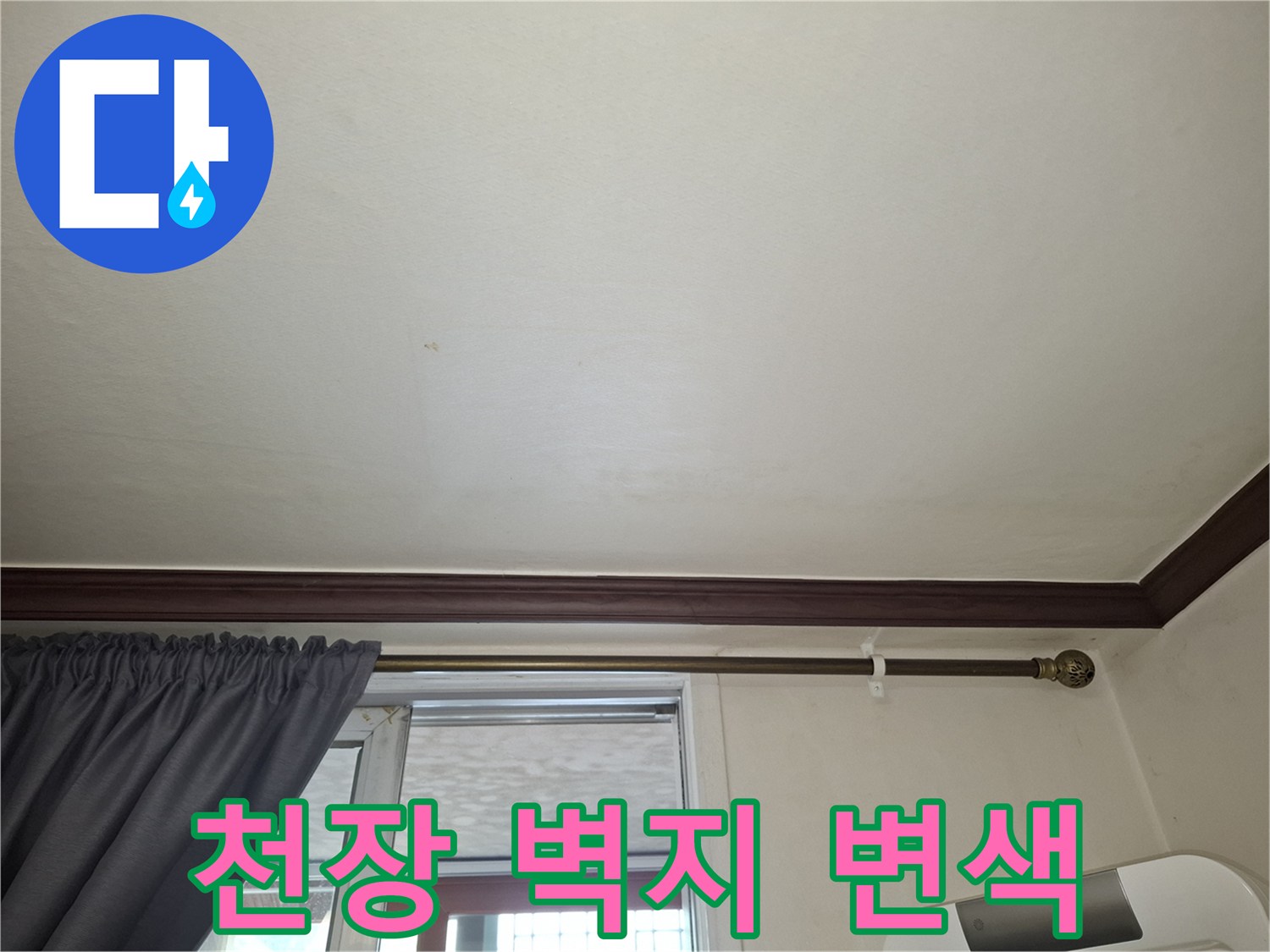 거실 천장 벽지에 나타난 미세한 습기 흔적과 변색 부위