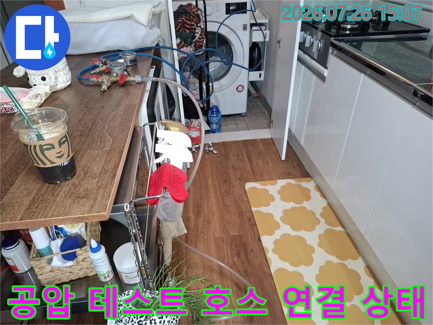 주방 가구 위에 설치된 누수 탐지용 파란색 고무 호스와 측정 장치-검사 준비 완료