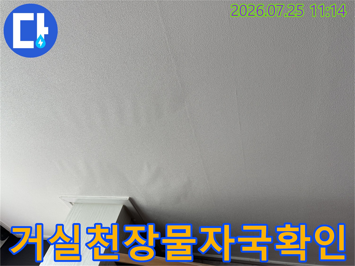 아파트 거실 천장면에 발생한 물자국과 변색 부위의 상태를 점검하는 모습