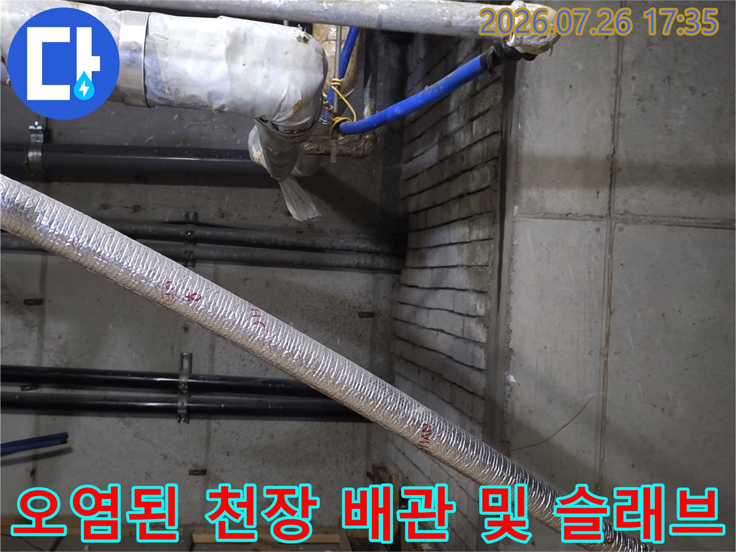 천장에서 물이 새어 나와 변색된 콘크리트와 설치된 설비 배관들-사진