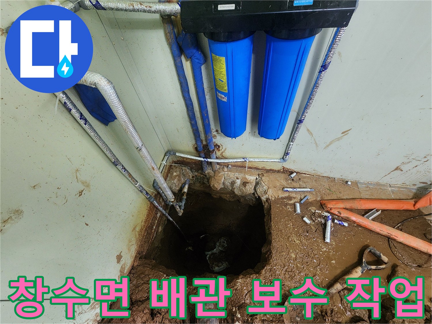 정수 장치 근처의 젖은 흙과 드러난 배관 연결 부위 모습