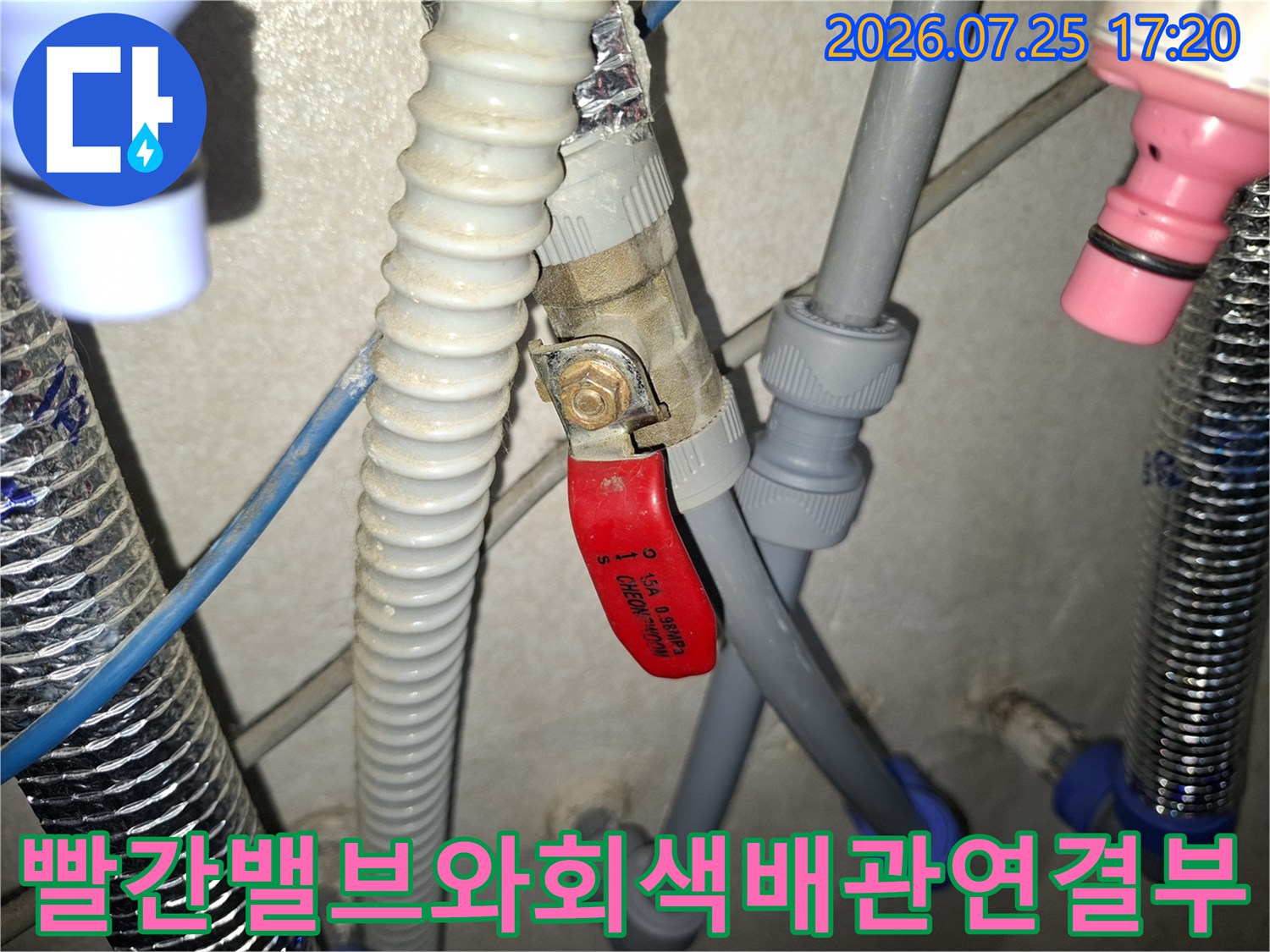 회색 배관과 빨간색 핸들 밸브가 연결된 누수 지점 모습