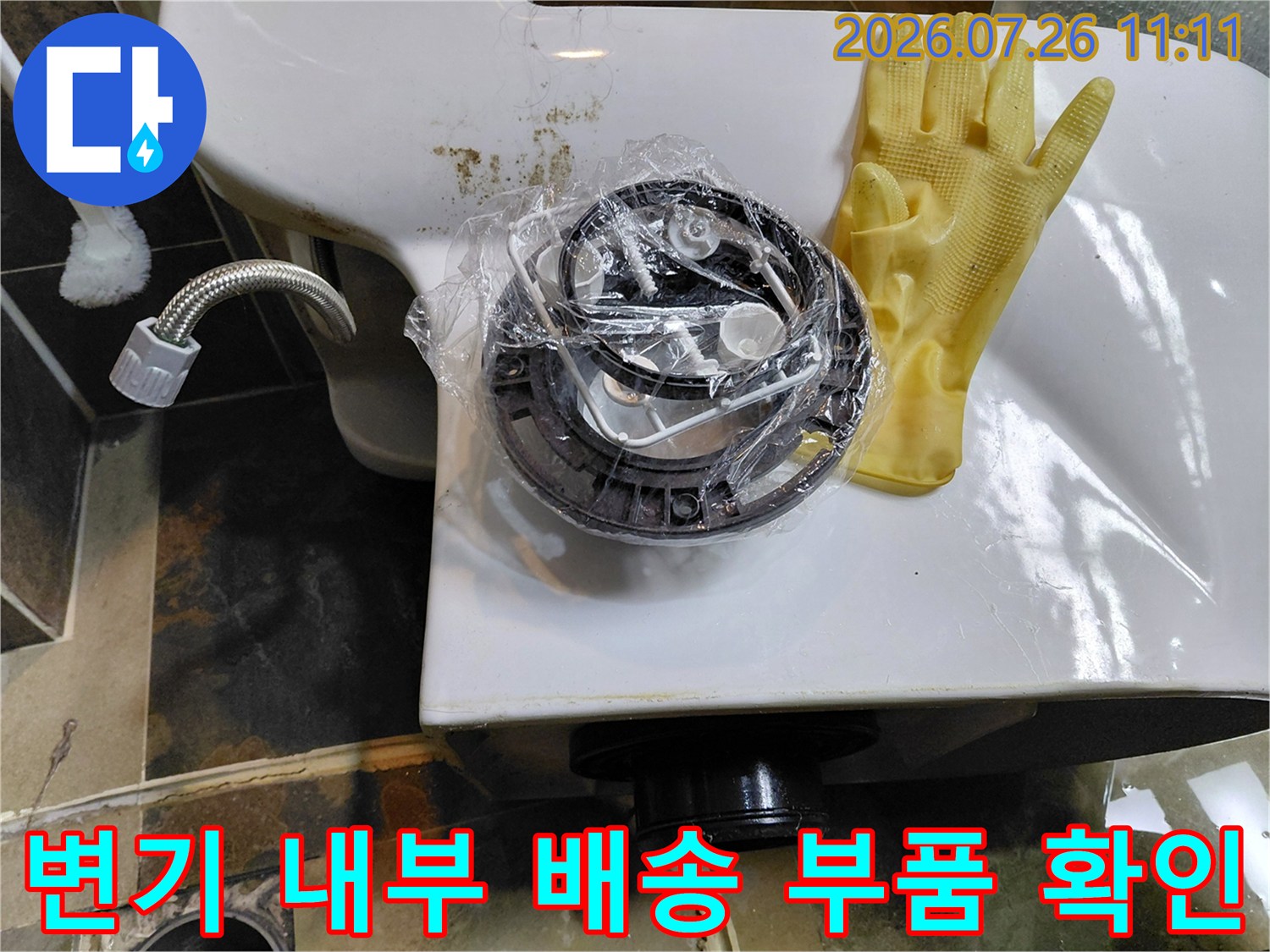 탈거된 변기 아래의 배수 장치와 연결부 상태를 면밀히 살피는 장면