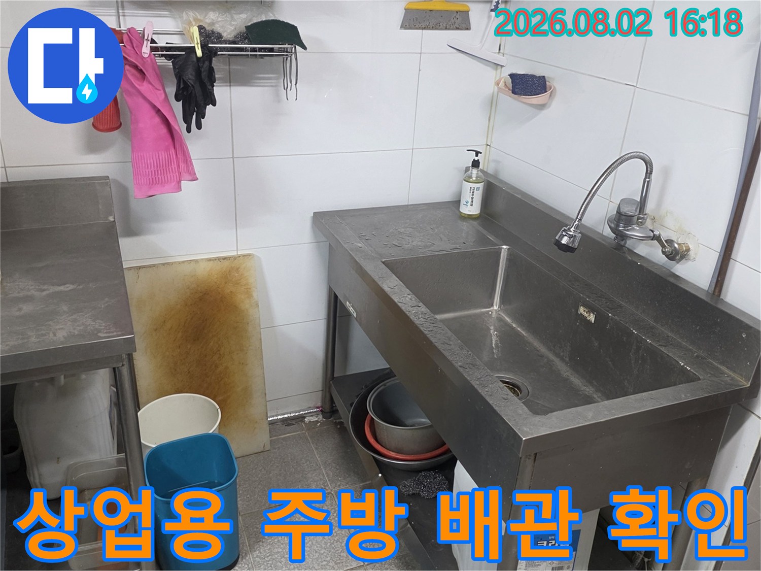 스테인리스 싱크대 아래 배치된 배관 및 하단 구조물