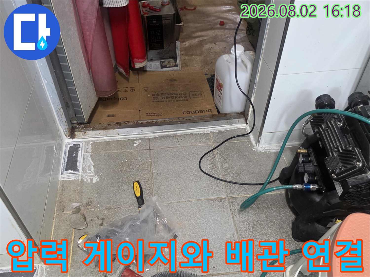 초록색 호스와 파란색 장비가 연결된 배관 압력 테스트 현장 사진