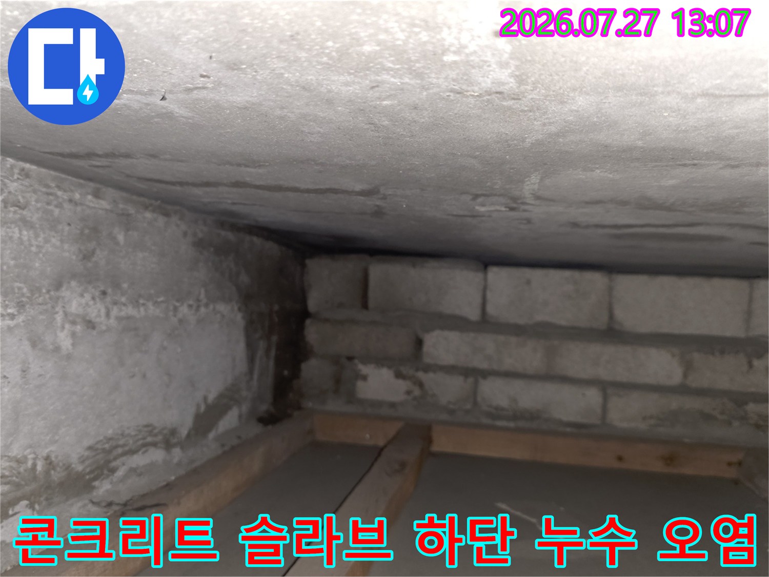 거칠게 마감된 천장 콘크리트 표면에 습기가 배어 나와 얼룩덜룩하게 변한 모습
