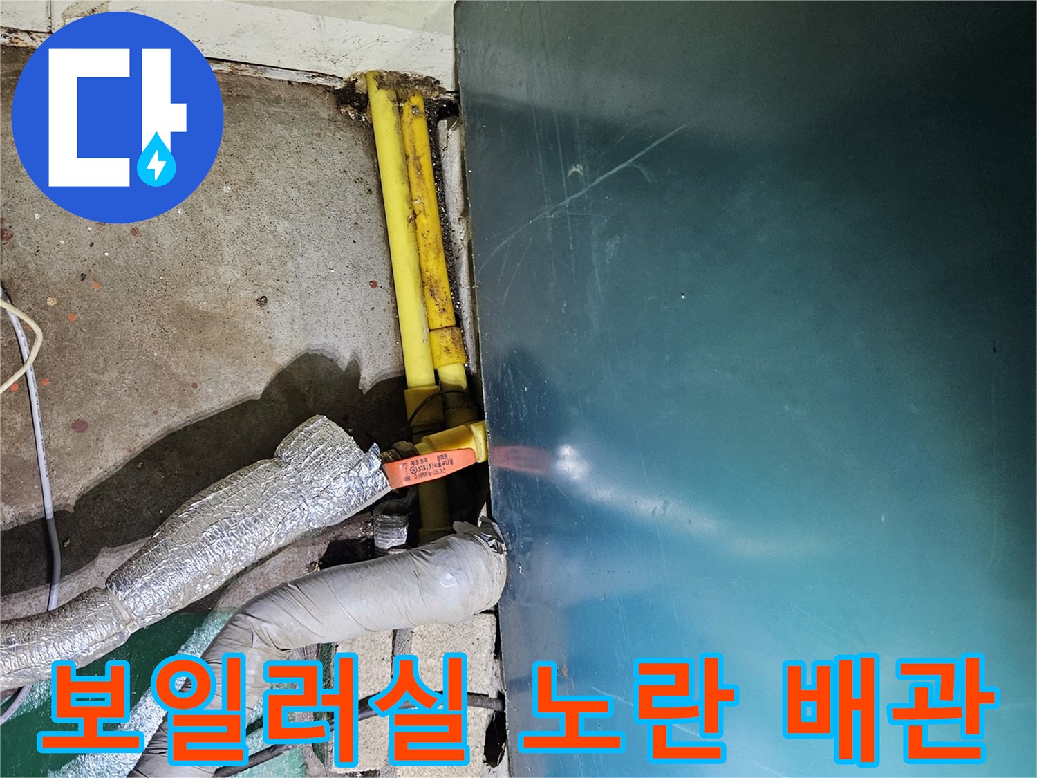 보일러실 바닥에 위치한 노란색 가스 배관과 보온재가 씌워진 배관의 모습