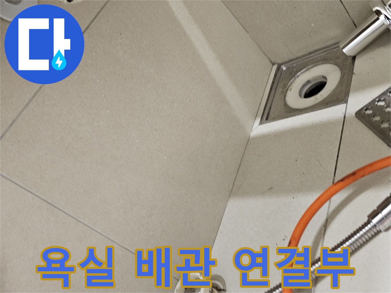 세면대 하단 벽면 타일과 노출된 배수 관로의 상세 모습
