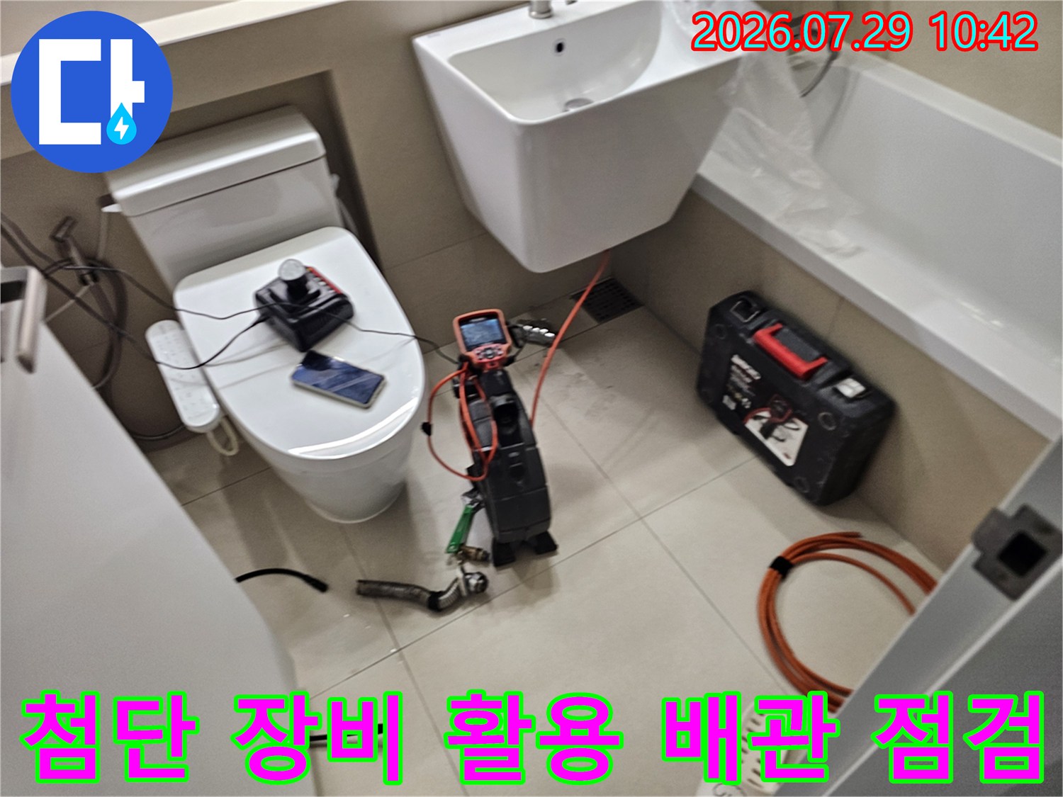 세면대 하부에 배치된 전문 측정기와 내시경을 통해 누수 발생 지점을 정밀하게 분석하는 모습