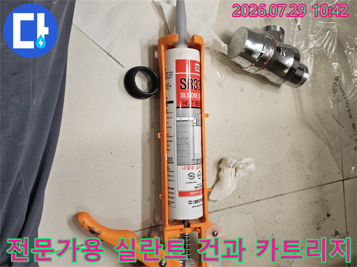 오렌지색 전동건을 사용하여 실란트를 도포하는 작업 현장 모습