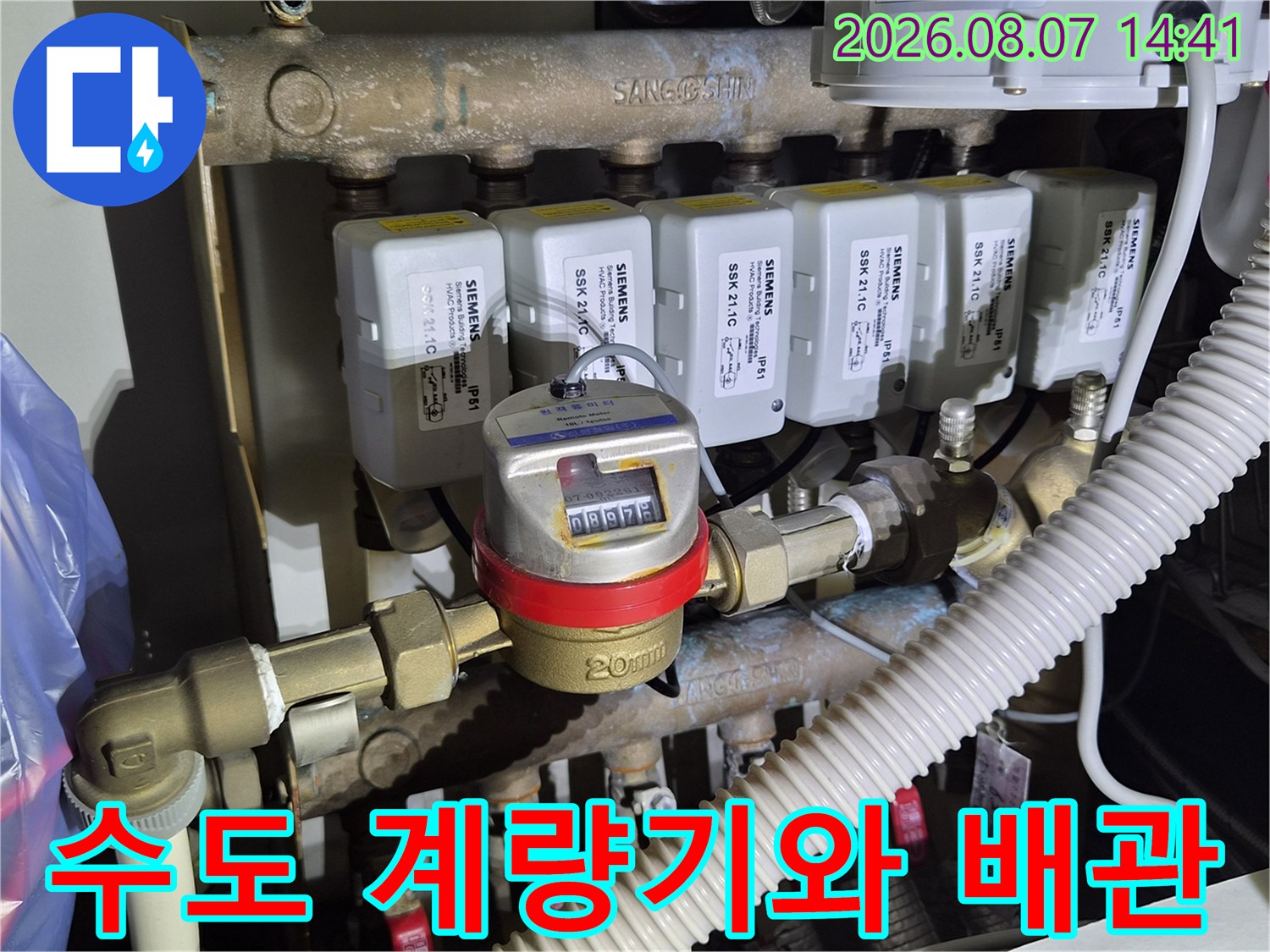 숫자가 기록된 계량기 본체와 연결된 황동색 배관들