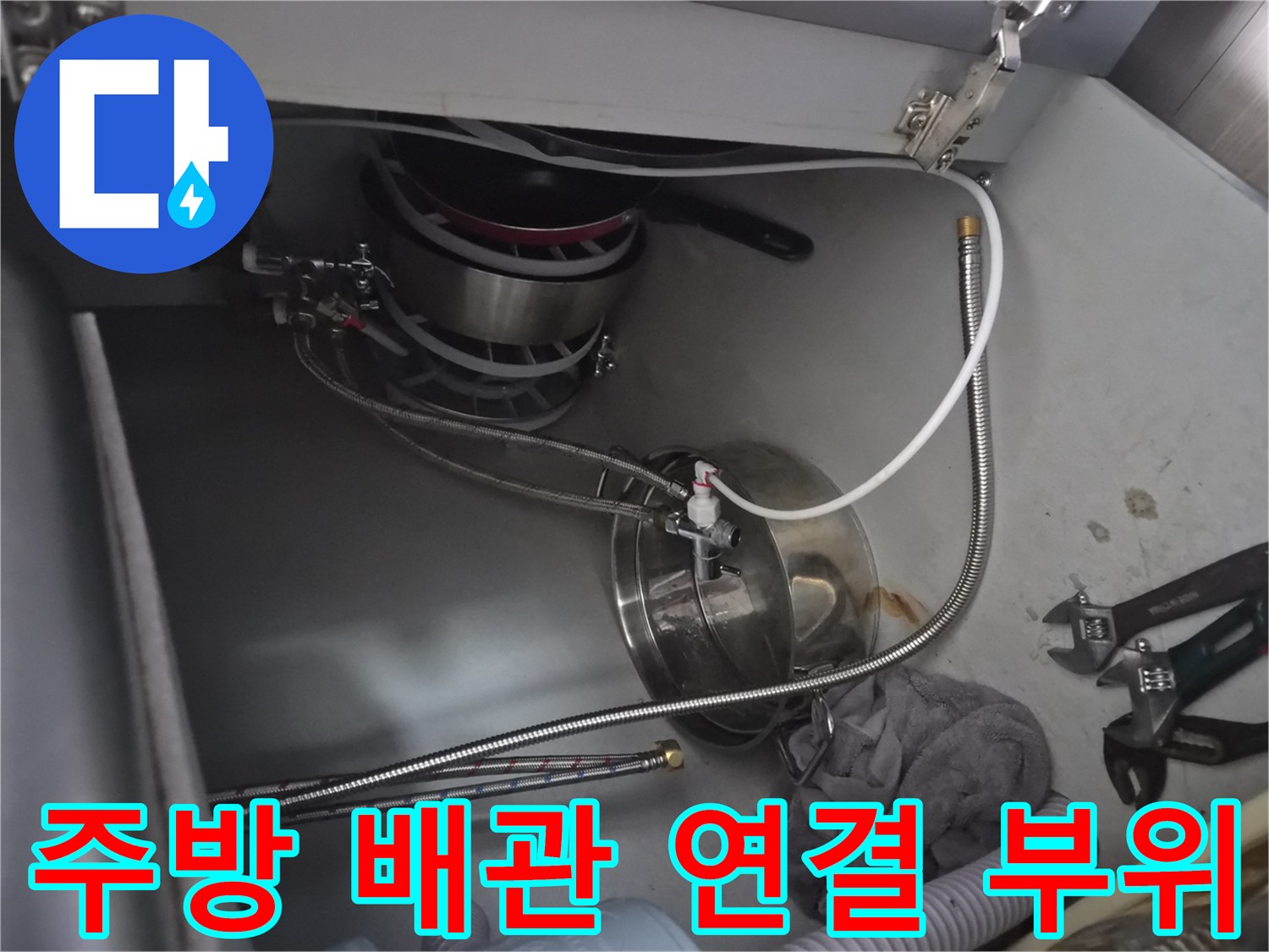 식기세척기 급수용 은색 호스와 싱크대 하부장 내 배관 구조