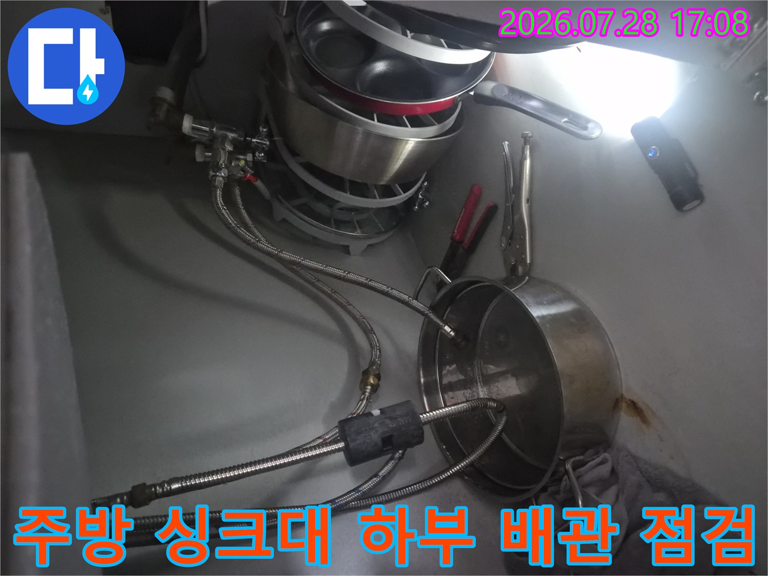 식기세척기와 연결된 수분 분배 밸브와 호스 구간의 누수 여부를 확인하는 모습