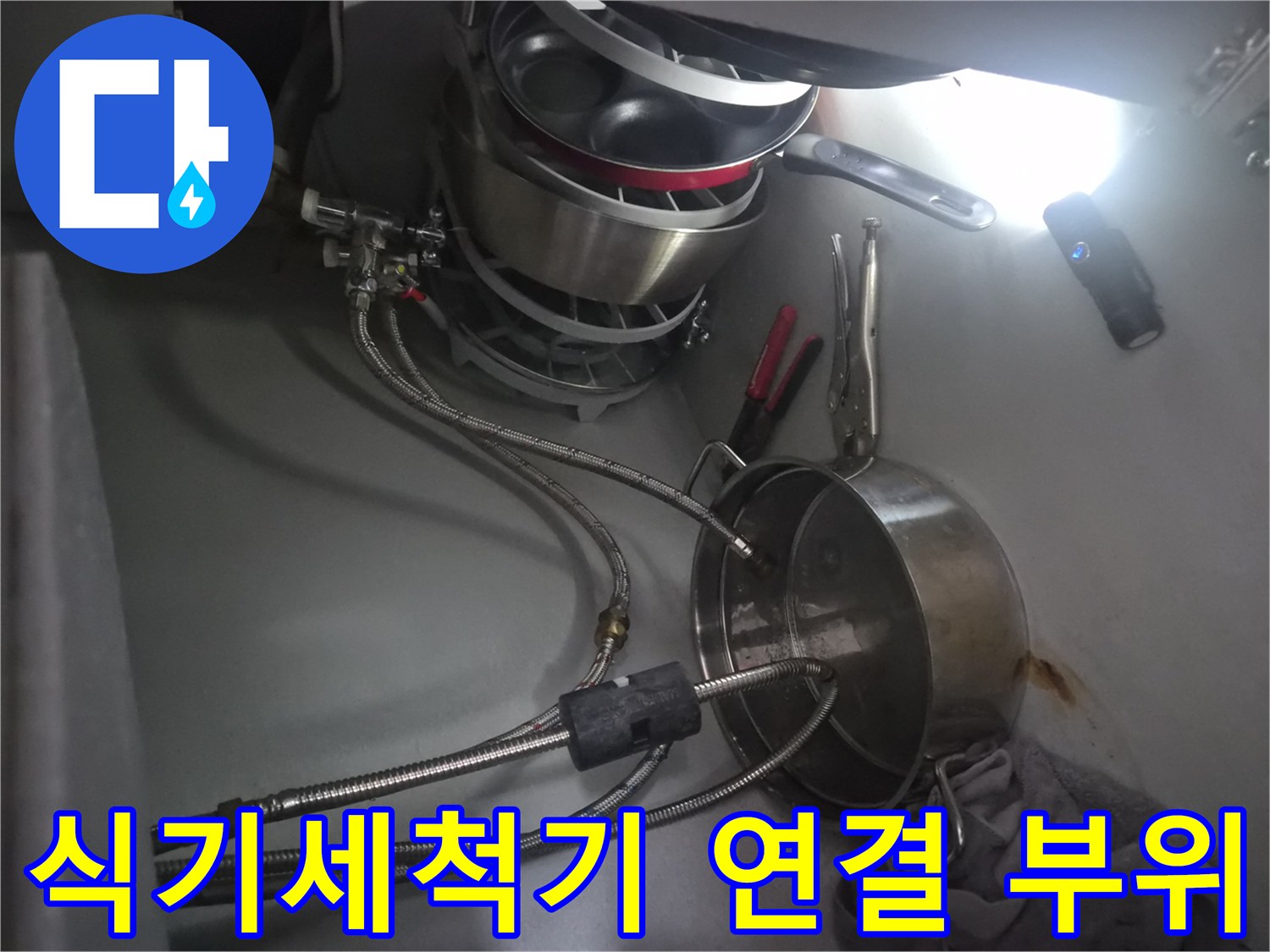 싱크대 아래쪽 식기세척기 급수 호스와 밸브 근접 사진