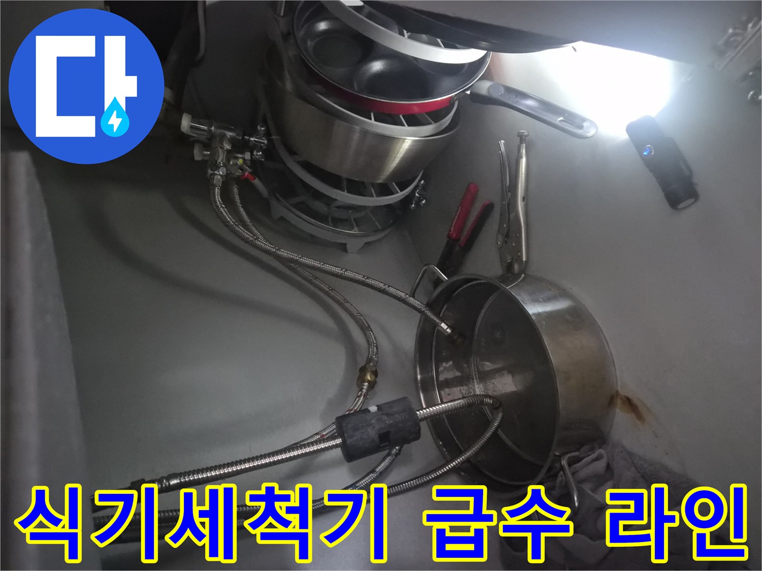 싱크대 하단 냄비 뒤쪽의 식기세척기 연결 호스 및 어댑터