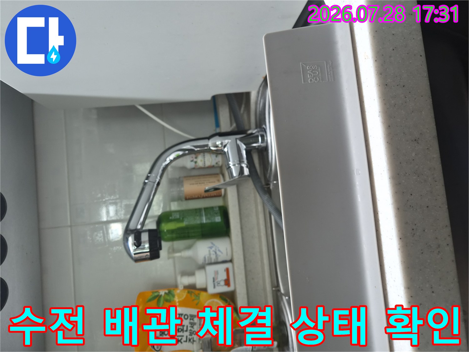싱크대 하부의 수전과 식기세척기 연결 부위를 상세히 점검하는 모습