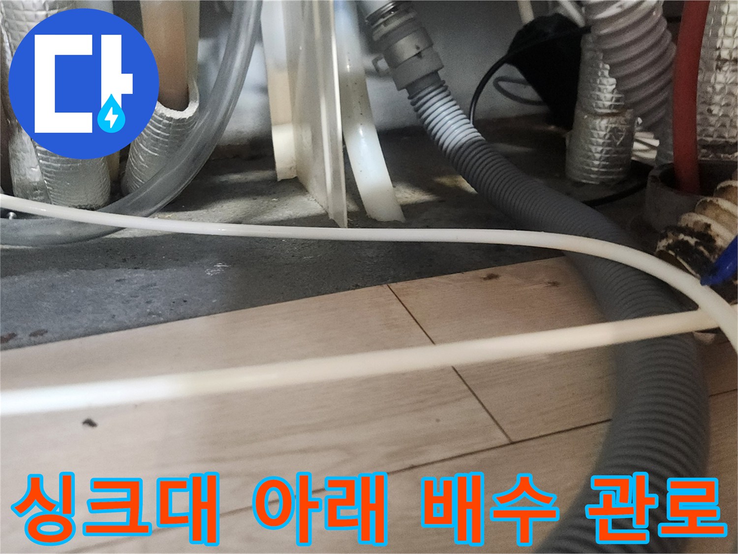 싱크대 밑 복잡하게 얽힌 여러 가닥의 배수 호스들