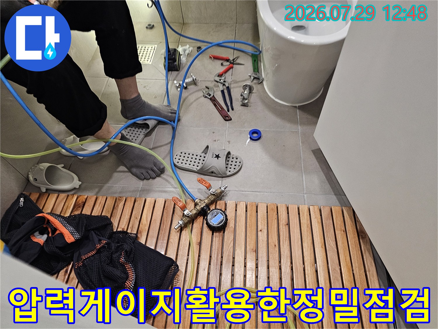 전문가용 압력계와 세척 장치를 연결해 배관 내부를 정교하게 청소하는 모습