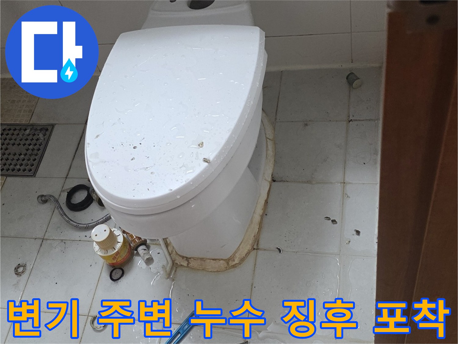 축축하게 젖은 변기 하단 타일과 작업용 공구의 배치 모습