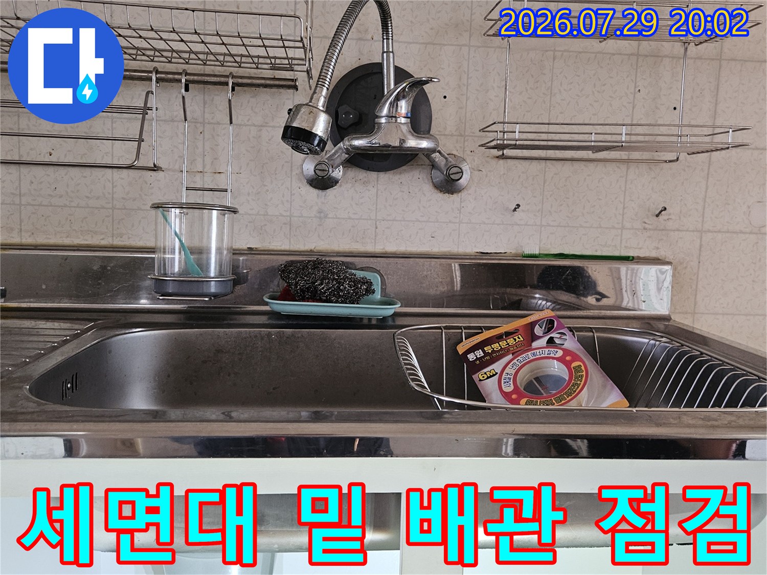 세면대 하부의 수전 연결 라인과 부속품들의 노후 상태를 정밀하게 파악하는 현장 사진