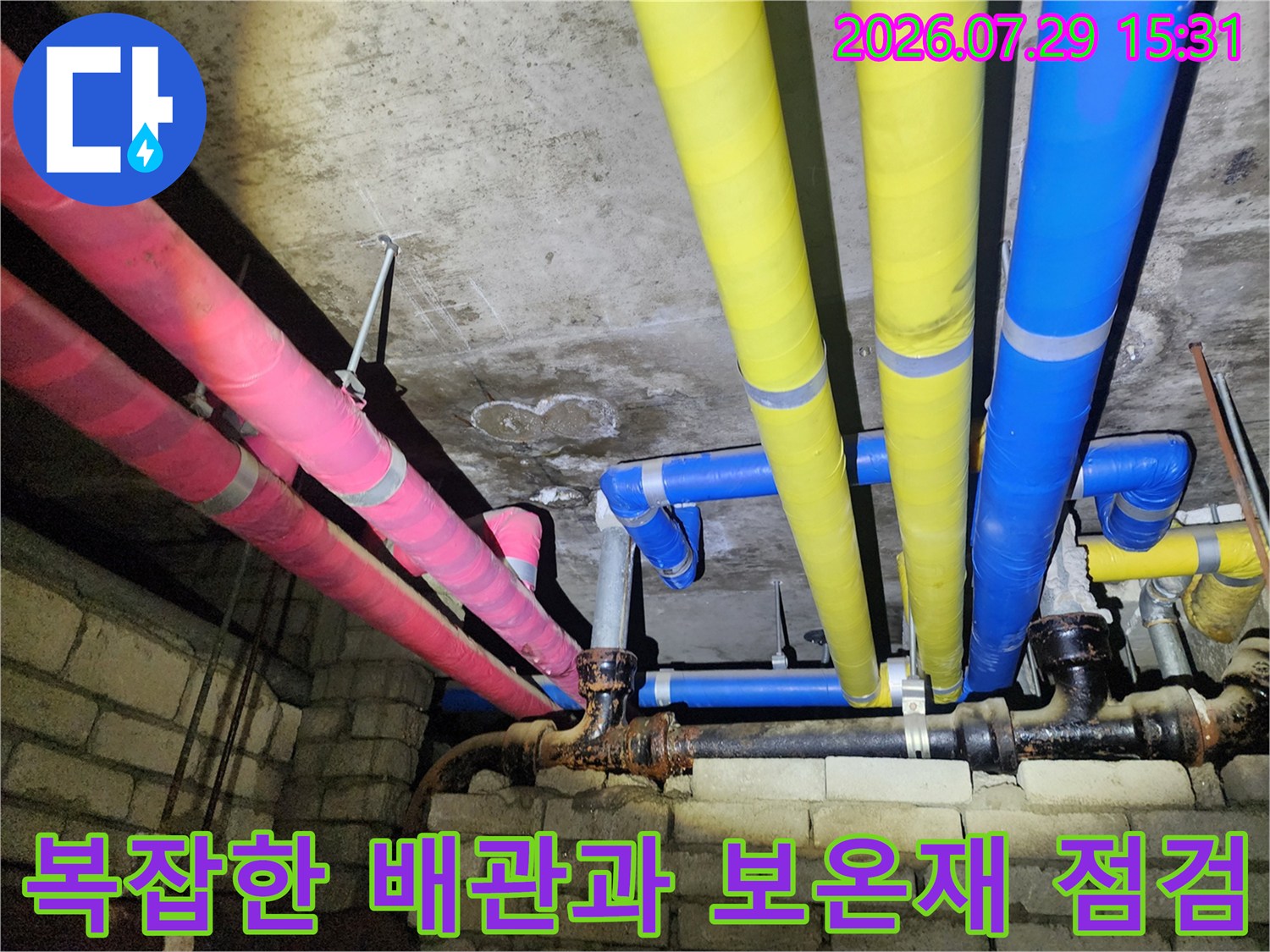천장 내부에 설치된 분홍색 파란색 노란색의 복합적인 배관 시스템