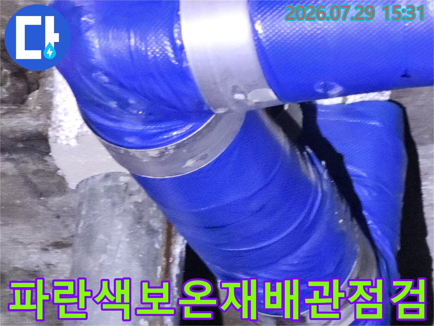 파란색 보온재로 감싸진 배관 연결 부위 점검 모습