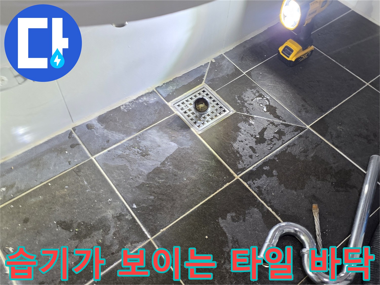 조명 아래 비춰진 - 물기가 스며든 배수구 주변 타일 부위