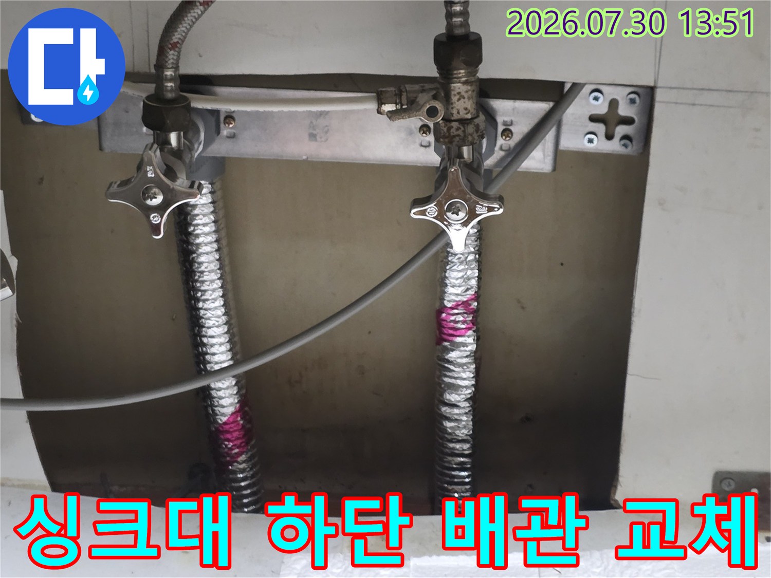 스테인리스 주름관과 고정 브래킷으로 보강된 싱크대 아래 급수 배관