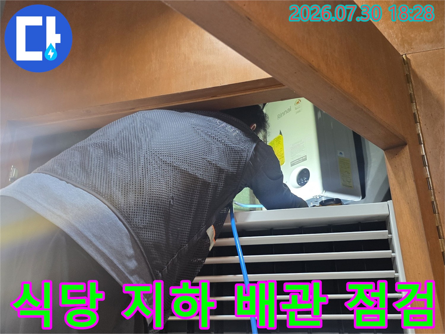 작업자가 식당 지하 공간에서 배관의 누수 여부를 확인하며 세밀하게 점검하는 모습