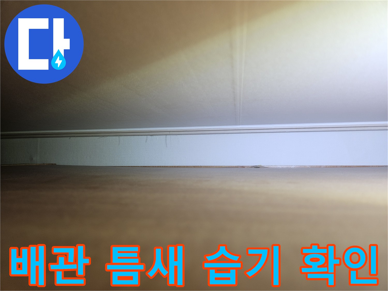 장롱 하단 마감재와 배관 사이의 연결 상태를 촬영한 사진입니다.