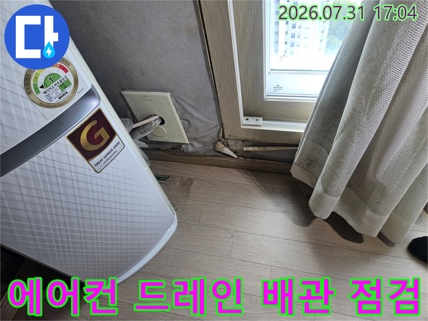 에어컨 실내기 하단부의 배수 배관과 연결 부위를 정밀하게 점검하는 모습