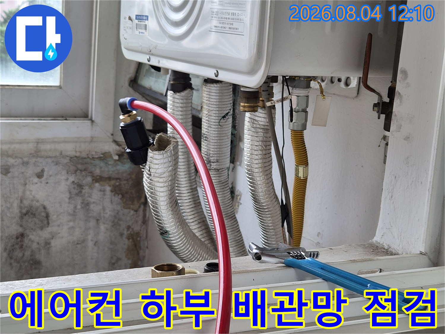 노출된 여러 갈래의 배관과 파란색 몽키스패너가 비치된 누수 진단 현장