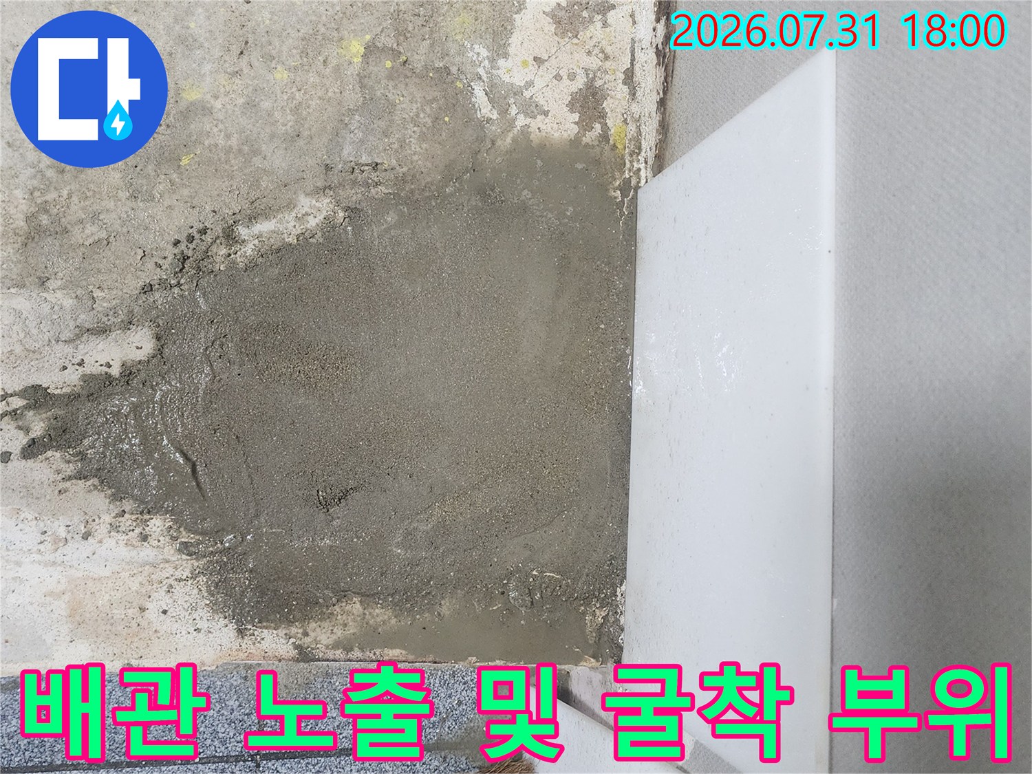 벽면 하단 시멘트를 파내어 드러난 배관과 주변 토사