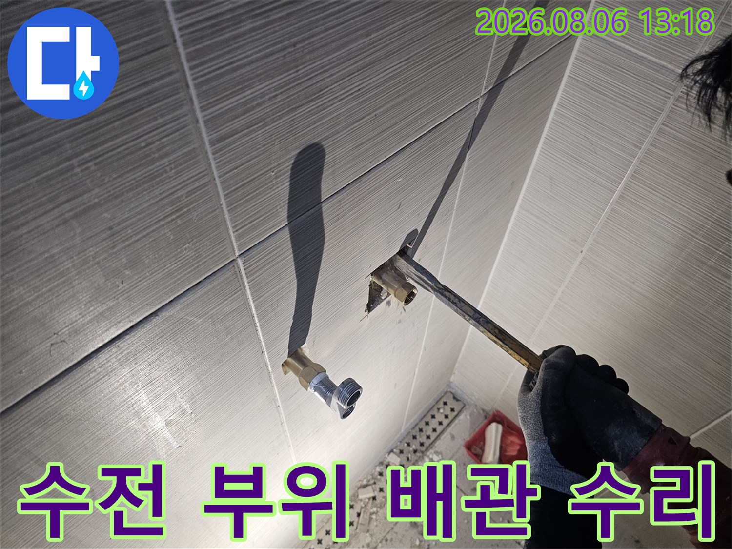 화장실 내 누수가 발생하는 수전 연결 배관을 점검하고 보수 계획을 세우는 모습