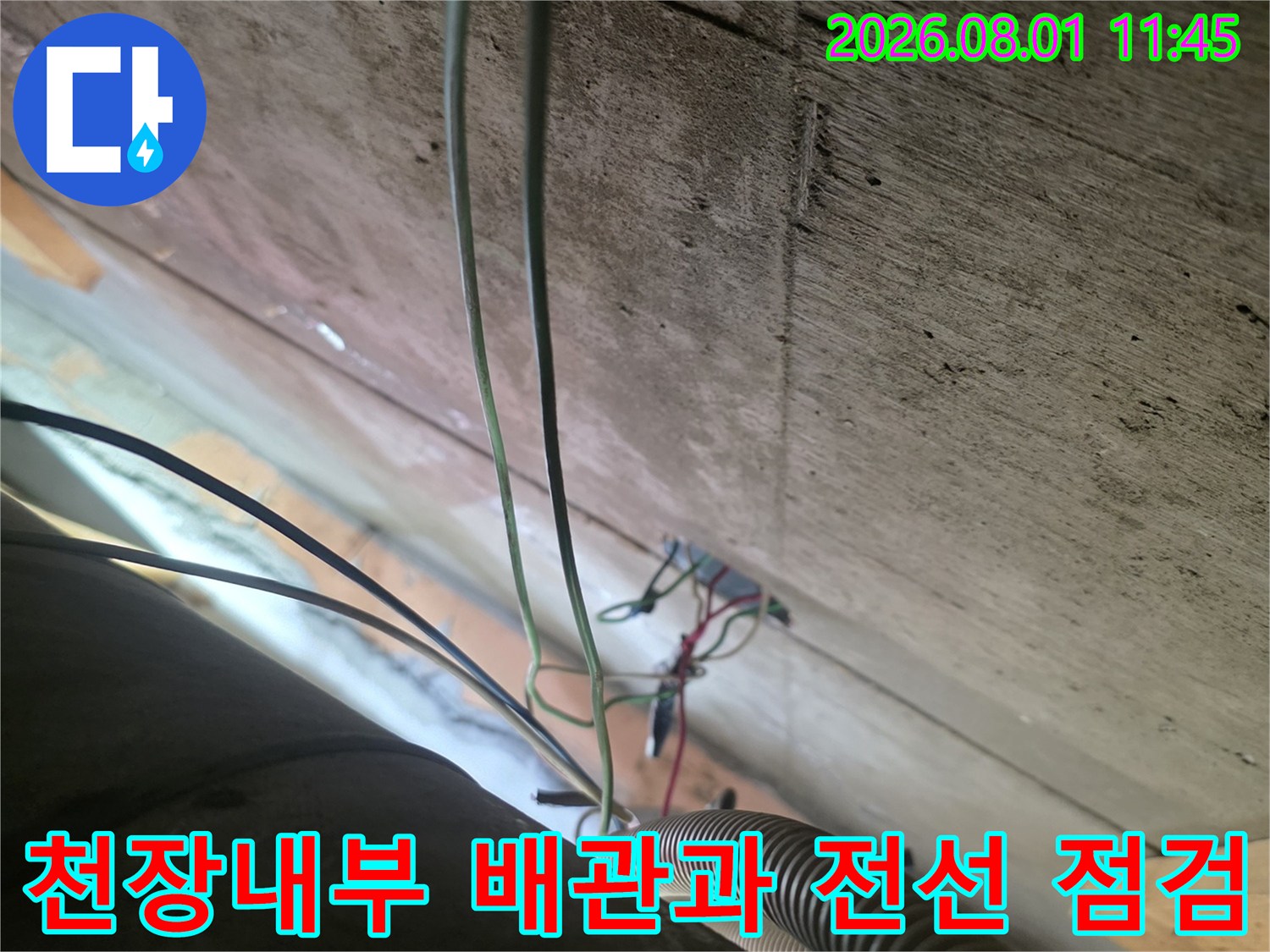 노출된 천장 내부의 전기 배선과 배관 연결 부위를 정밀하게 점검하는 모습