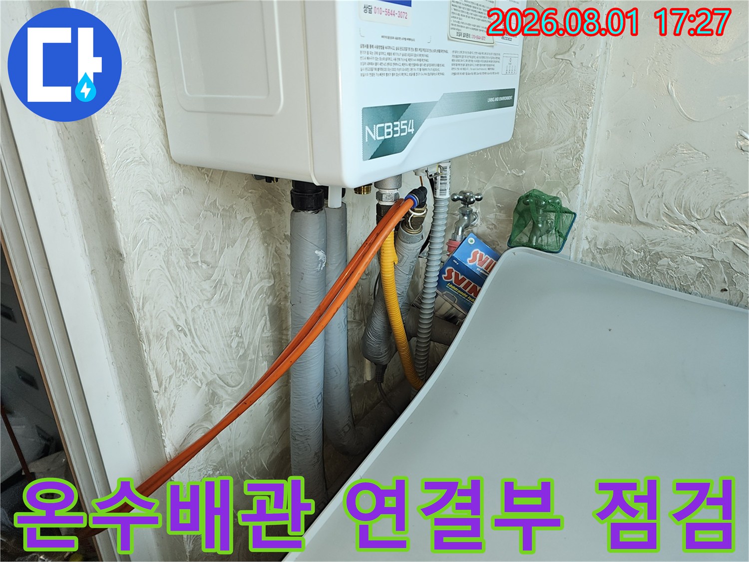 노출된 온수 배관과 직수 배관의 연결 부위를 정밀하게 점검하는 모습