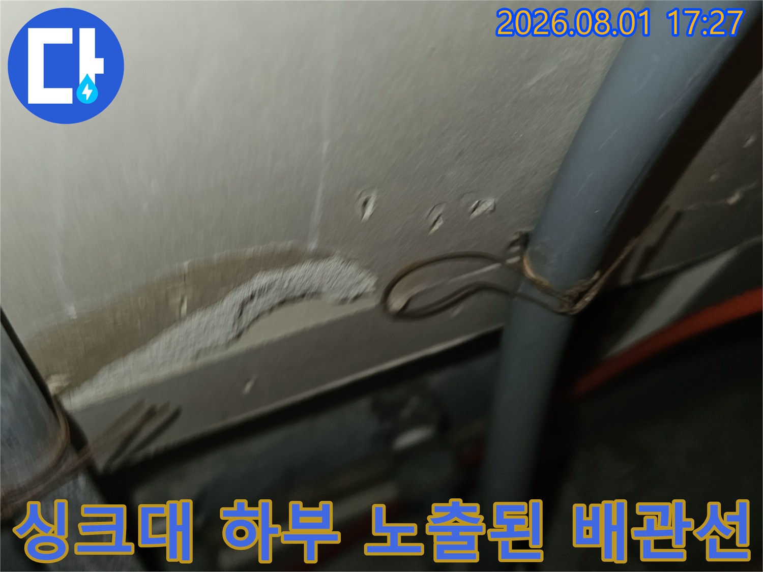 노출된 회색 배관과 고정용 클램프 및 연결 부위 촬영