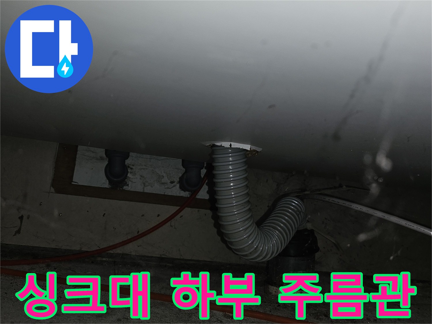 싱크대-하부-연결된-회색-주름관-및-벽면-배관