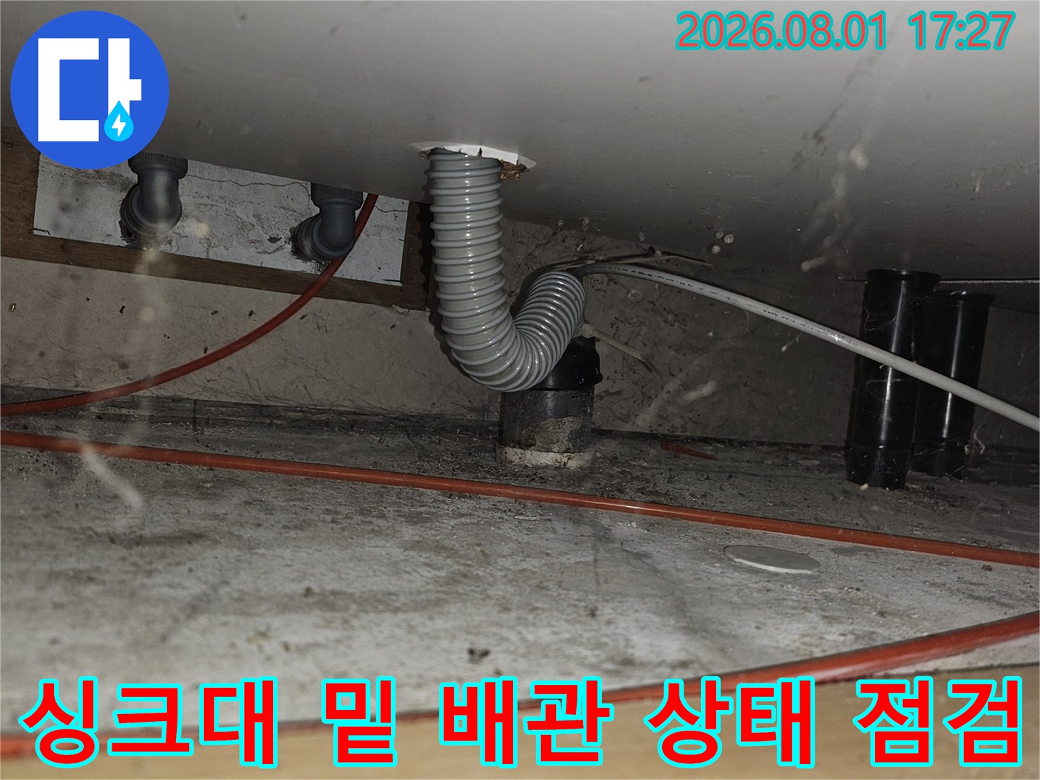 주방 싱크대 하부 공간에 노출된 주름형 배관과 연결 부위의 정밀 확인