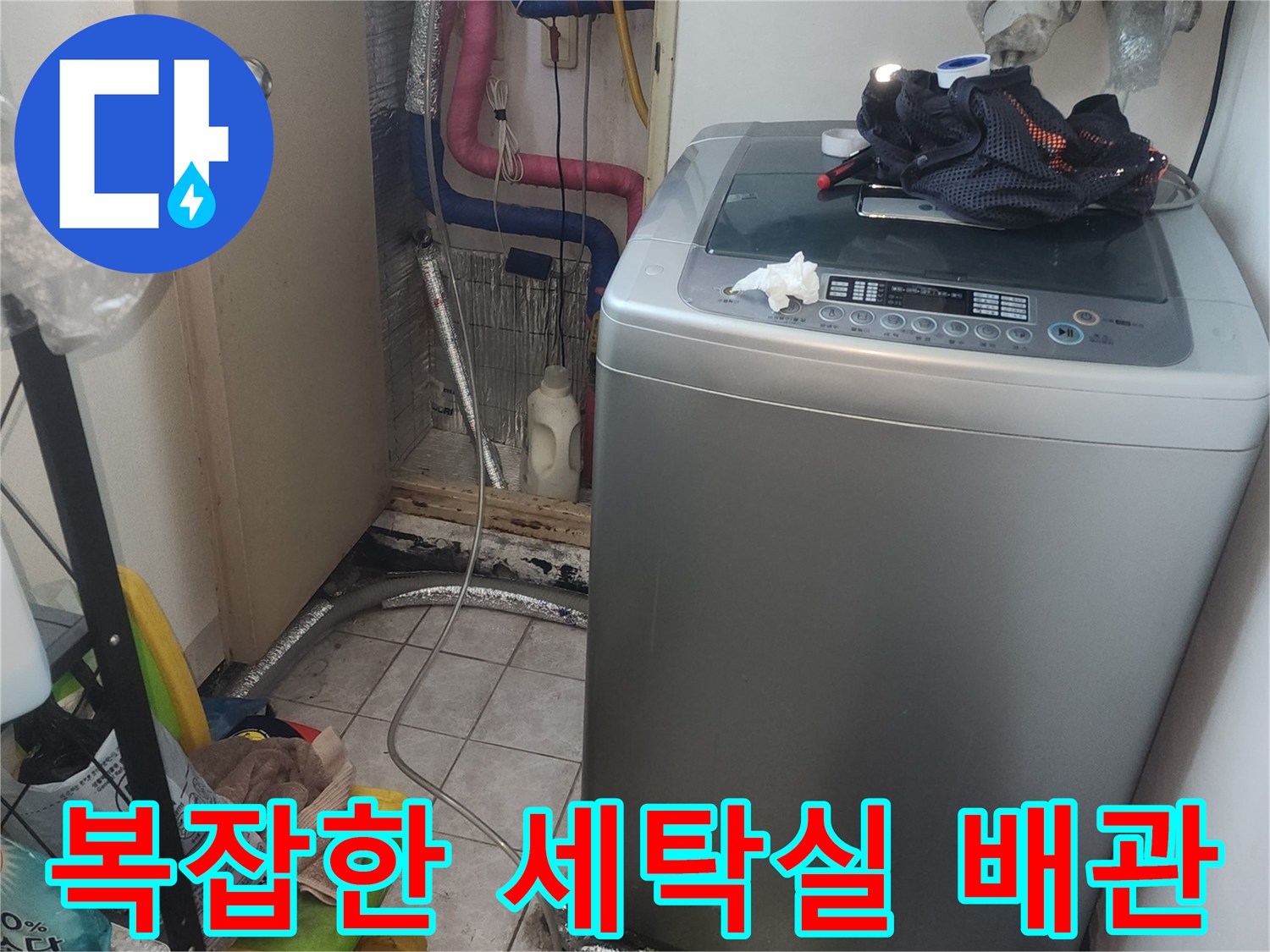세탁기 뒤쪽의 굴곡진 배관과 수도 호스 연결 부위 촬영