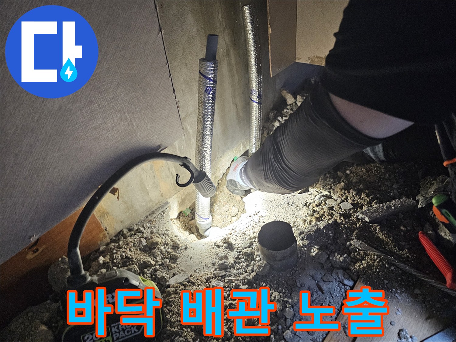굴착을 통해 드러난 보온재 감싸진 배관과 작업용 조명