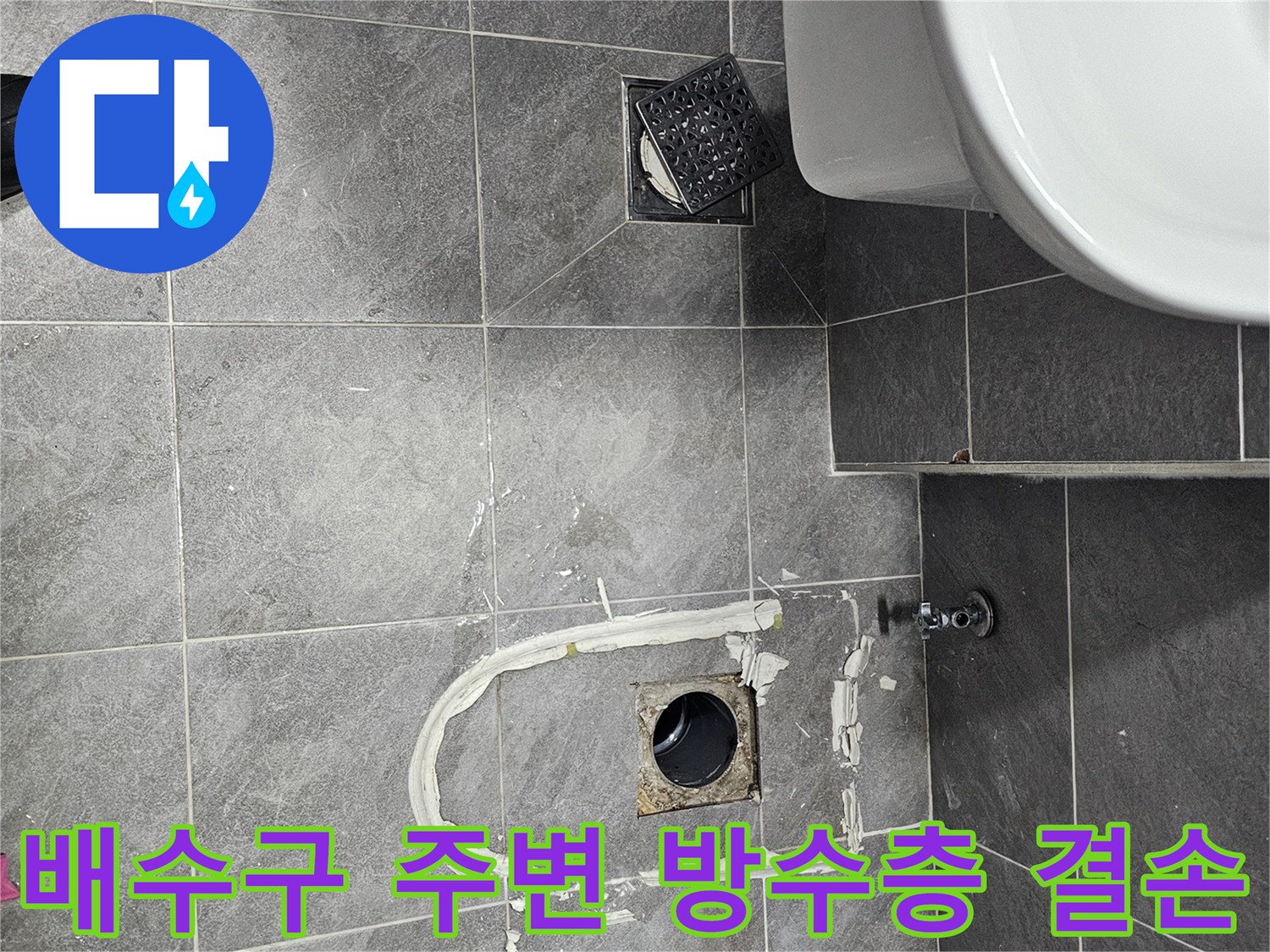 오수관 주변 타일 사이의 벌어진 틈과 물 고임 흔적