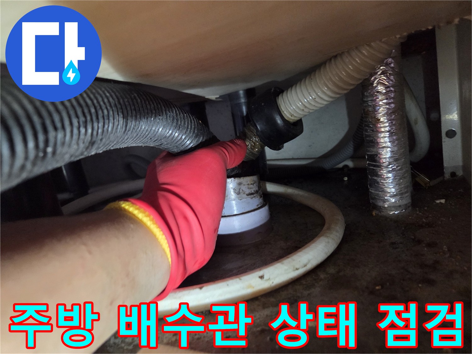 장갑을 낀 작업자가 싱크대 하단 배관 연결부를 만져보며 확인하는 사진