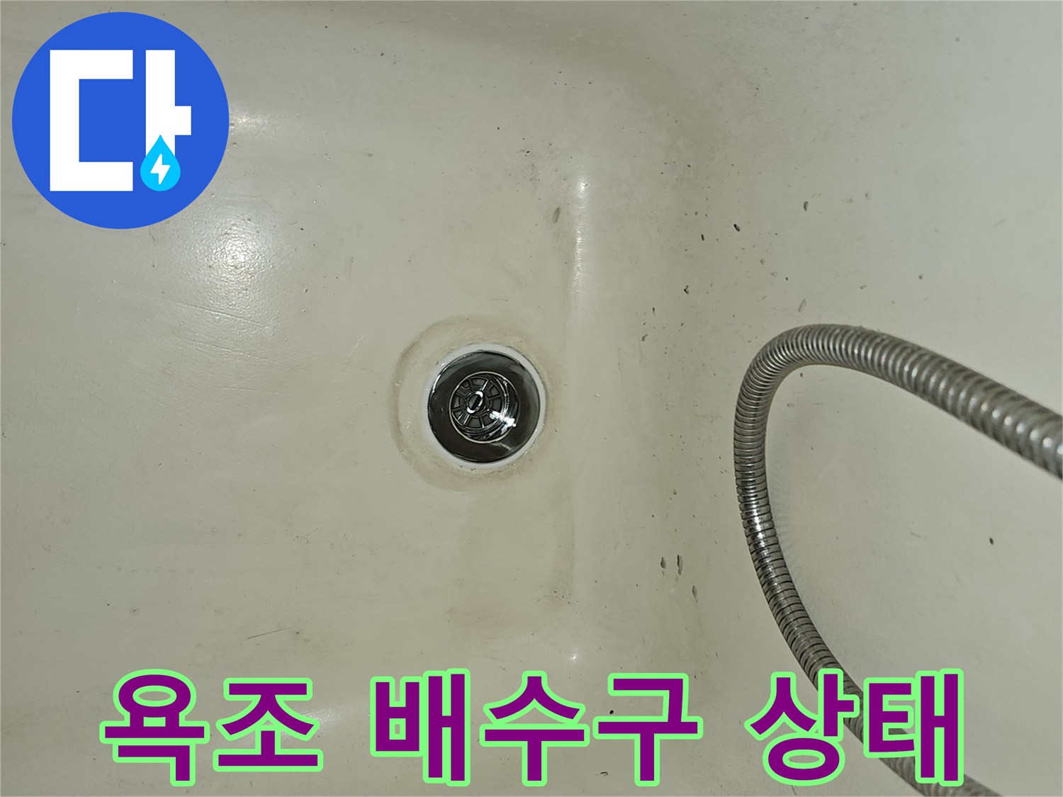 욕조 하부의 배수구와 샤워기 호스 모습입니다.